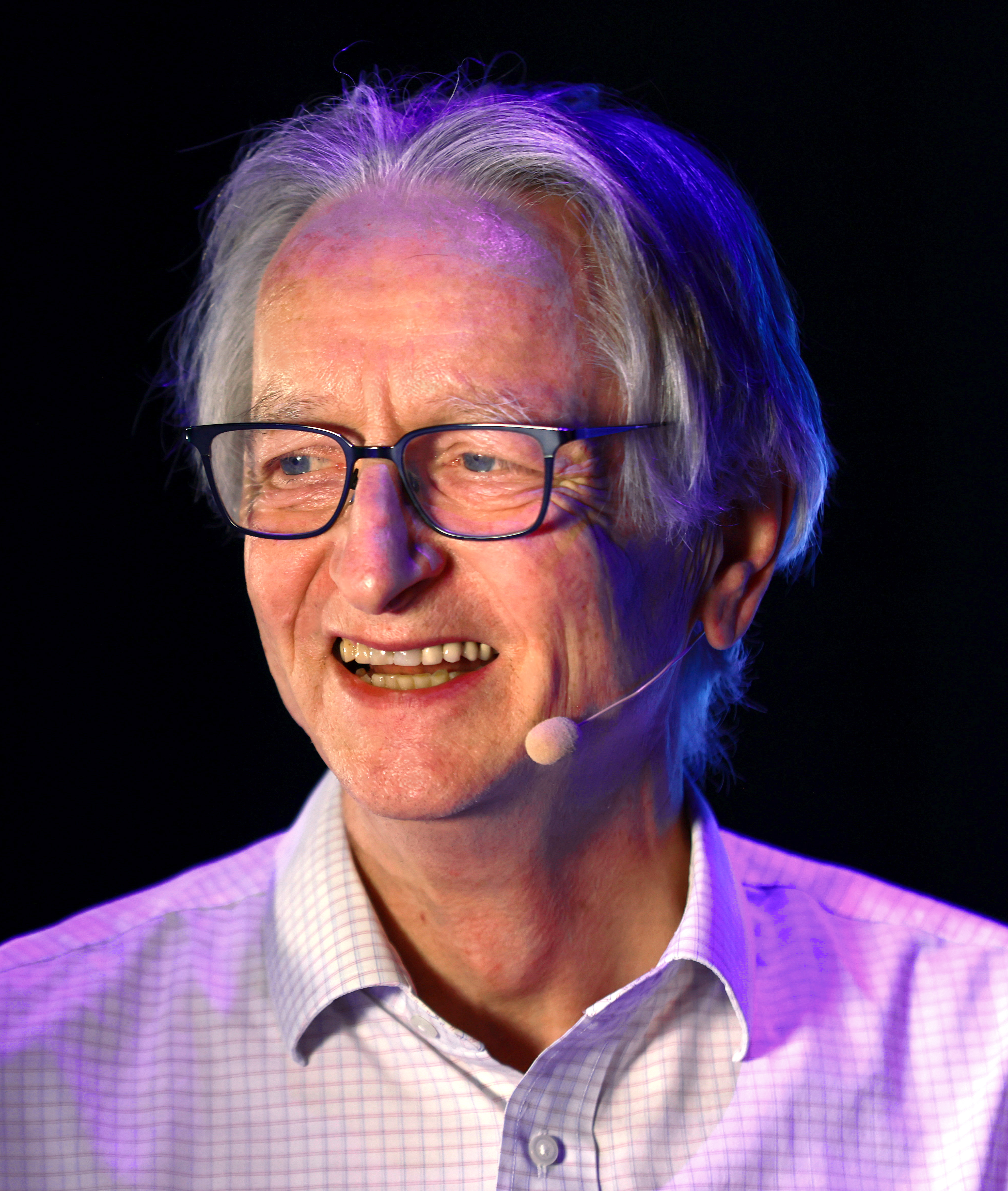 Geoffrey Hinton wearing glasses and a headset microphone at Collision 2024