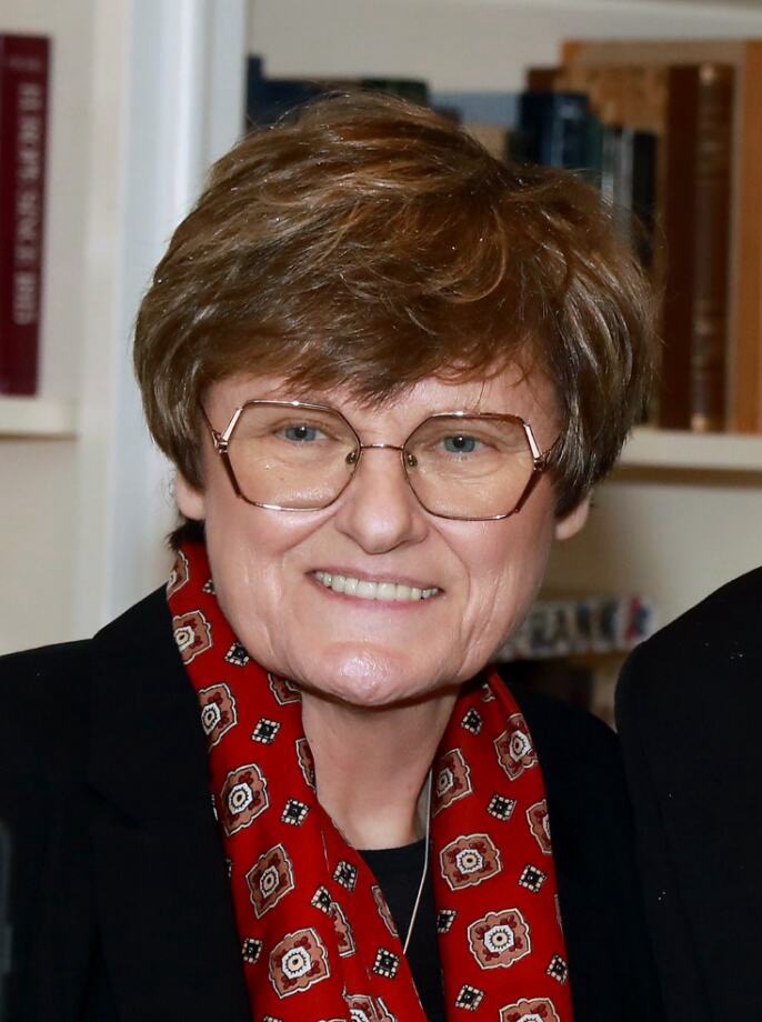 Katalin Karikó wearing glasses and a patterned red scarf at a 2023 Nobel reception